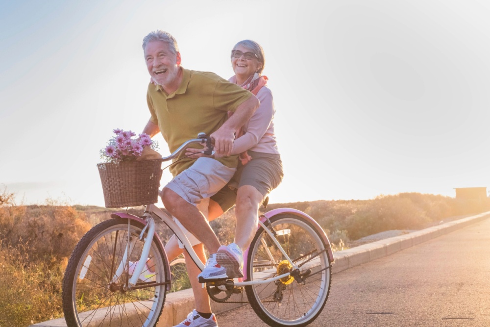 Smiling retired couple riding a bicycle