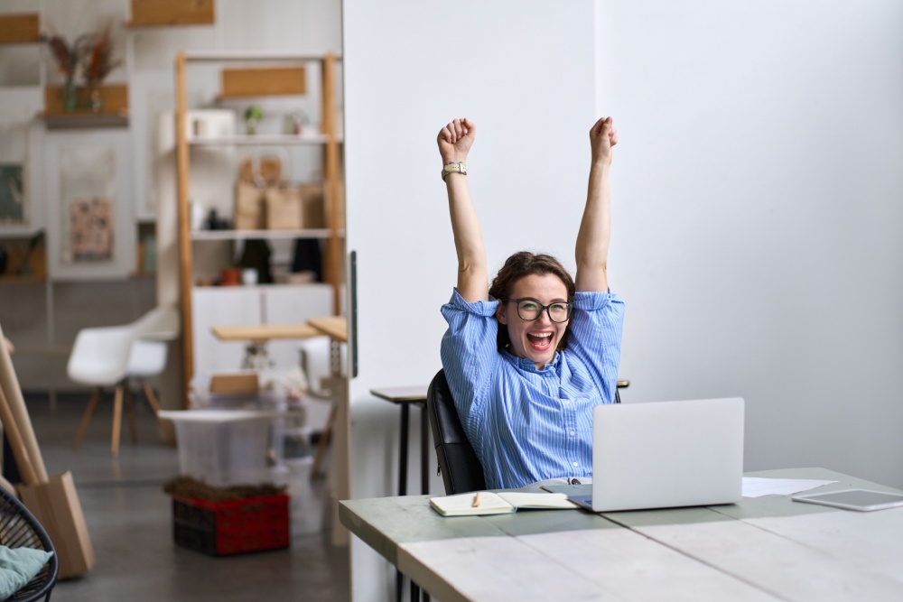 Happy and excited woman sitting at her laptop