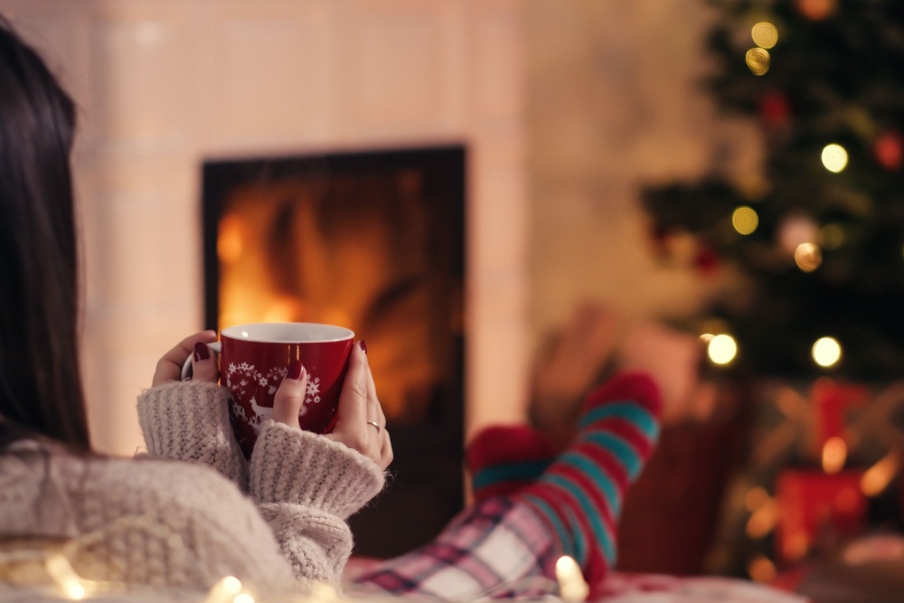 Woman with her feet up relaxing by a Christmas tree