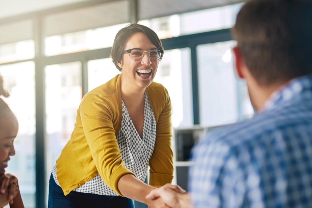 Happy business woman shaking hands