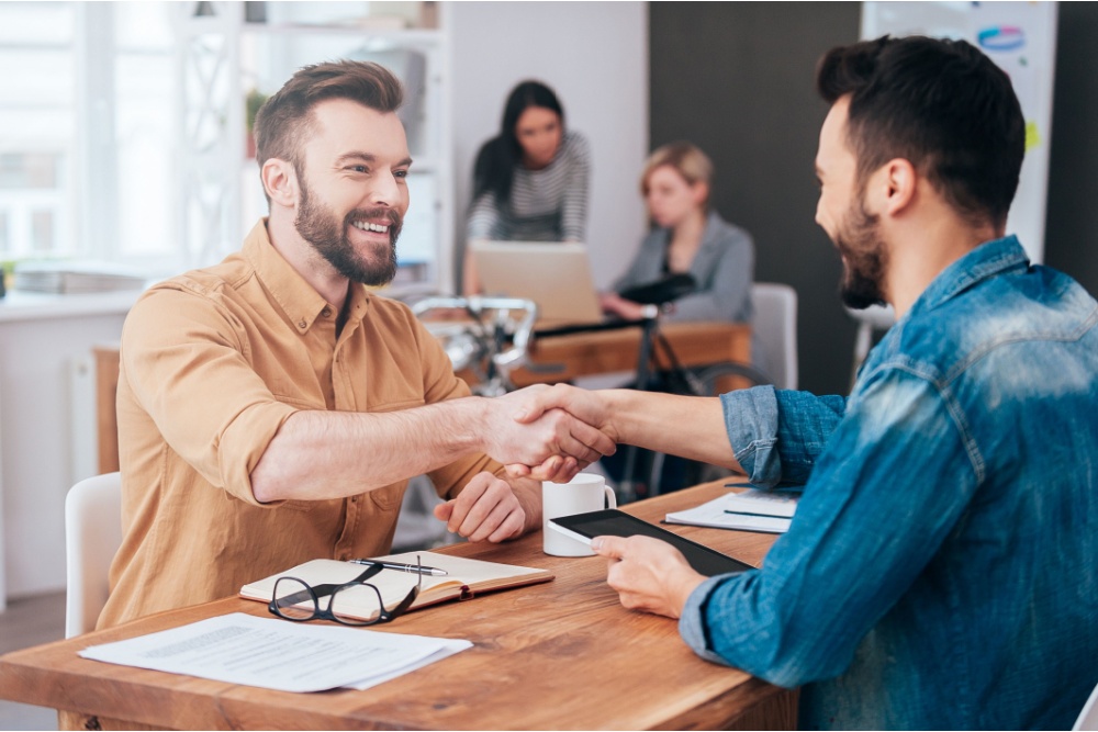 Two smiling men shaking hands