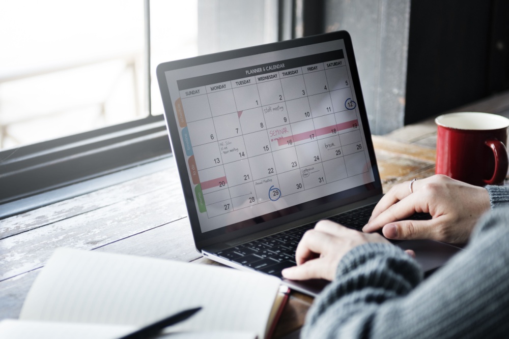 Woman editing a planner and calendar on a laptop